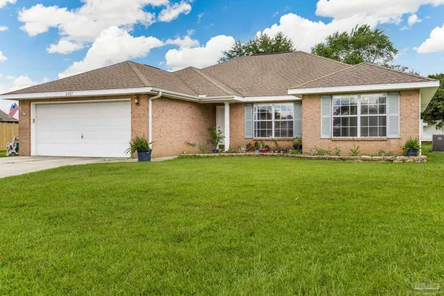 a front view of a house with a garden and yard