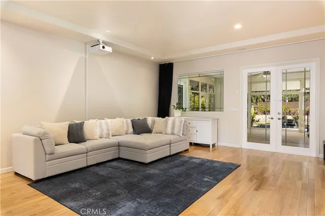 a view of an empty room with wooden floor and a ceiling fan
