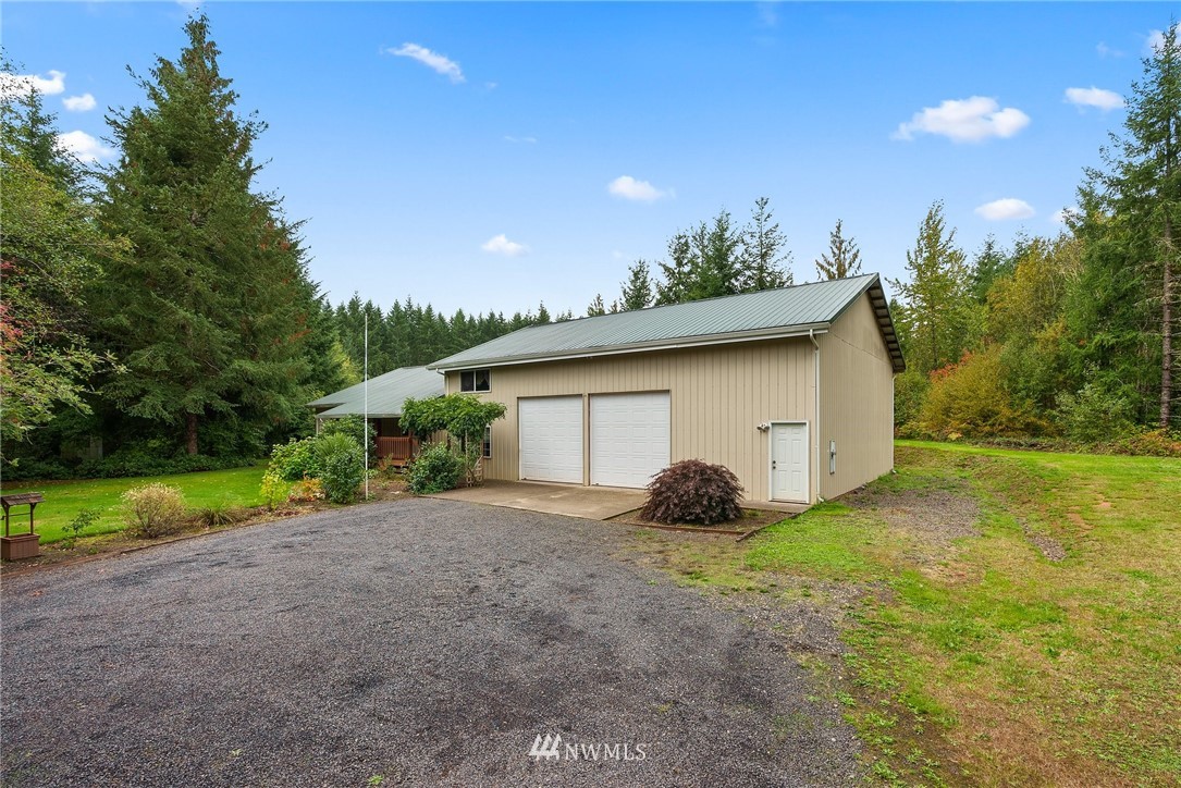 491 South Military Road Winlock, WA 98596 - Photo 2 of 40 a backyard of a house with plants and large tree