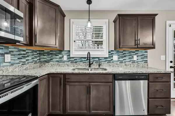 a kitchen with granite countertop a sink cabinets and window