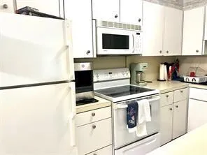a kitchen with stainless steel appliances white cabinets and a refrigerator