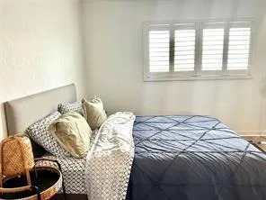 a bed sitting in a bedroom next to a window