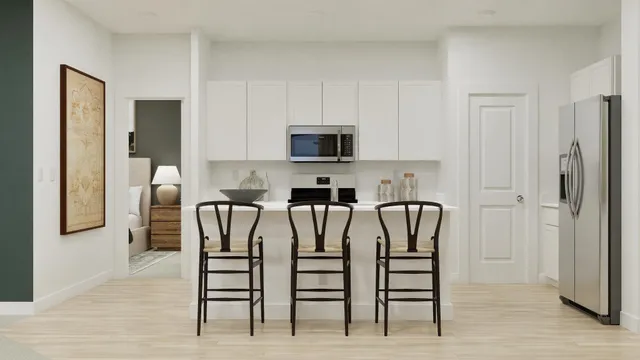 a kitchen with stainless steel appliances a table chairs and a refrigerator