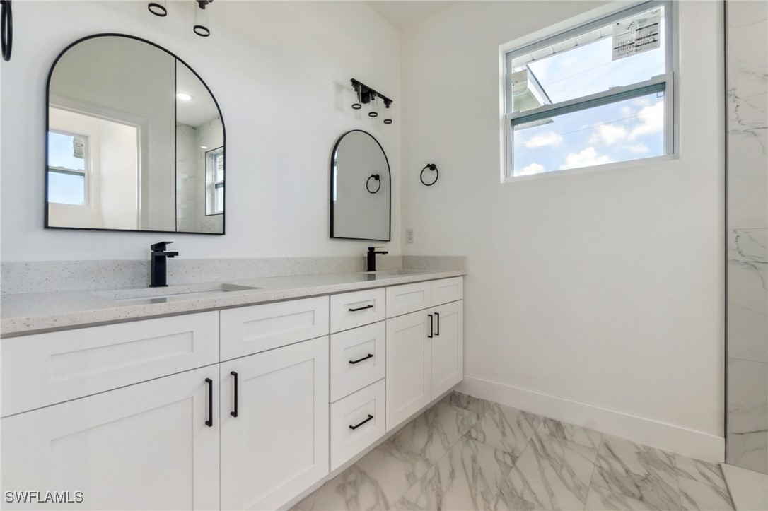 8 Cleat Court Placida, FL 33946 - Photo 16 of 24 a bathroom with a double vanity sink and mirror with window