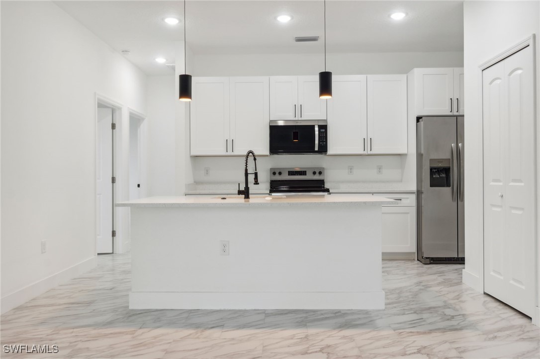 8 Cleat Court Placida, FL 33946 - Photo 10 of 24 a kitchen with kitchen island a white counter top space cabinets and stainless steel appliances