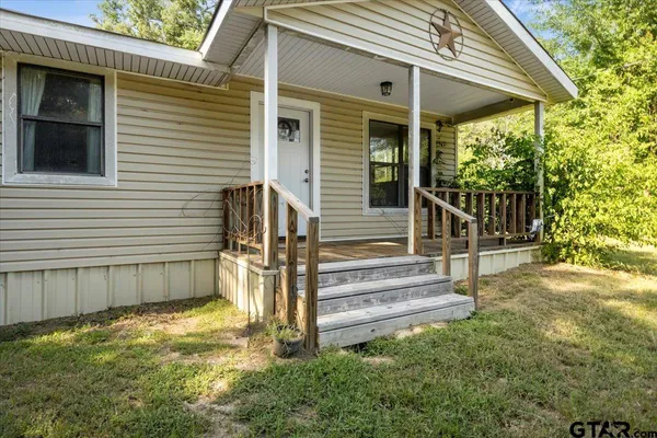 a view of a house with backyard and wooden fence
