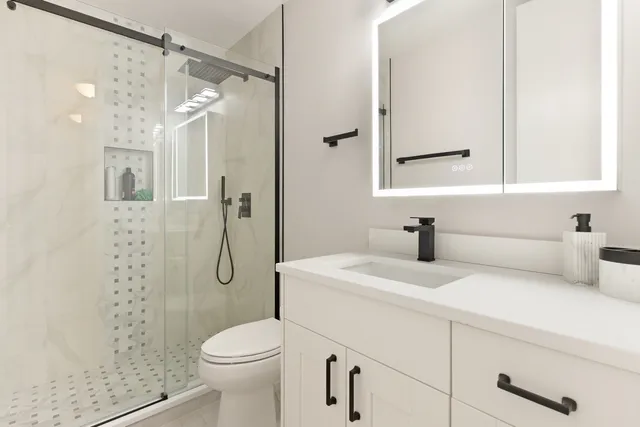 a bathroom with a sink a toilet and shower