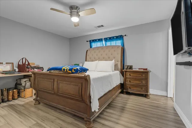 a bedroom with a bed and a flat tv screen on dresser