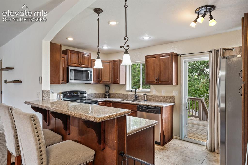 125 Diamond E Road Fountain, CO 80817 - Photo 2 of 43 a kitchen with a sink a center island a stove cabinets and a dining table