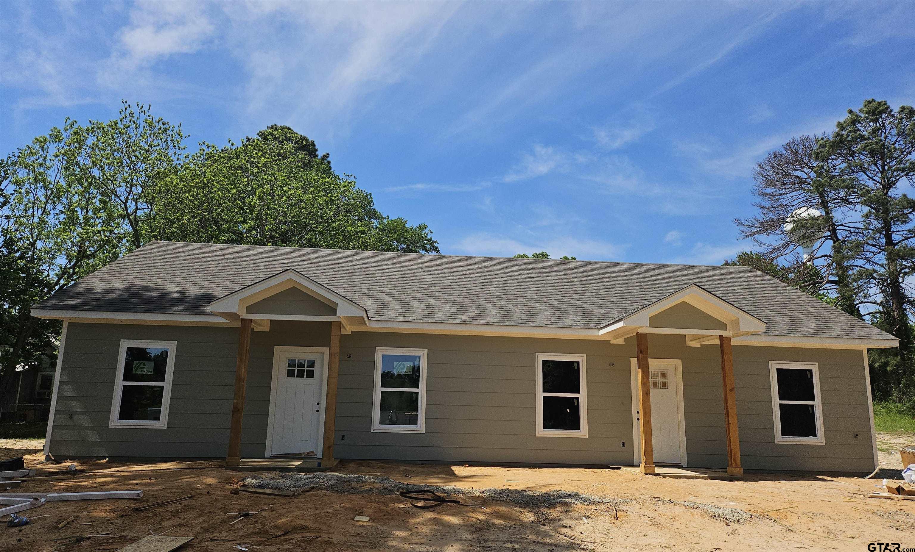 a view of a grey house with a yard