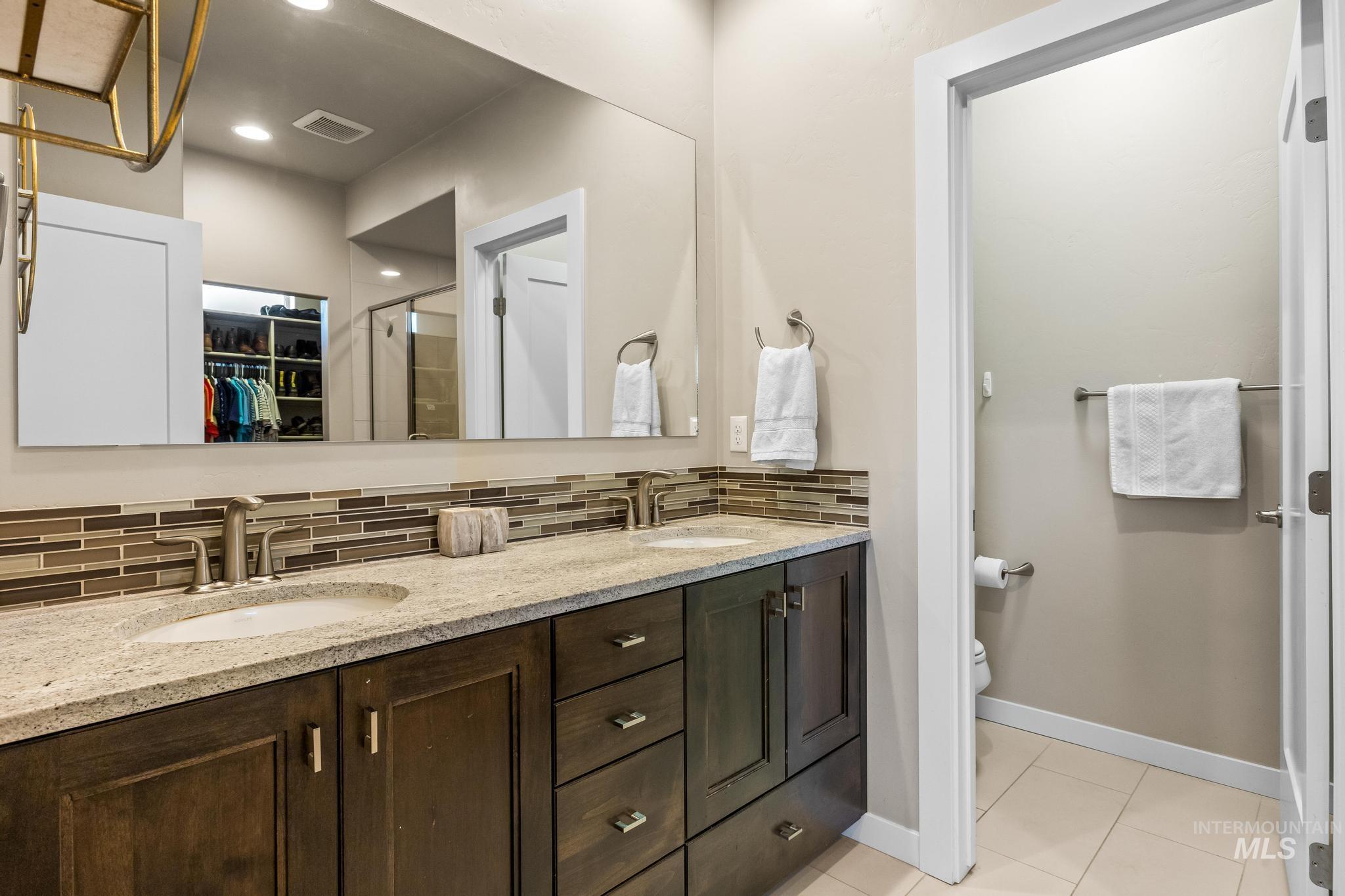 3362 East Exacta Lane Boise, ID 83716 - Photo 23 of 41 Full bath with a spacious closet, tasteful backsplash, double vanity, a stall shower, and light tile patterned flooring