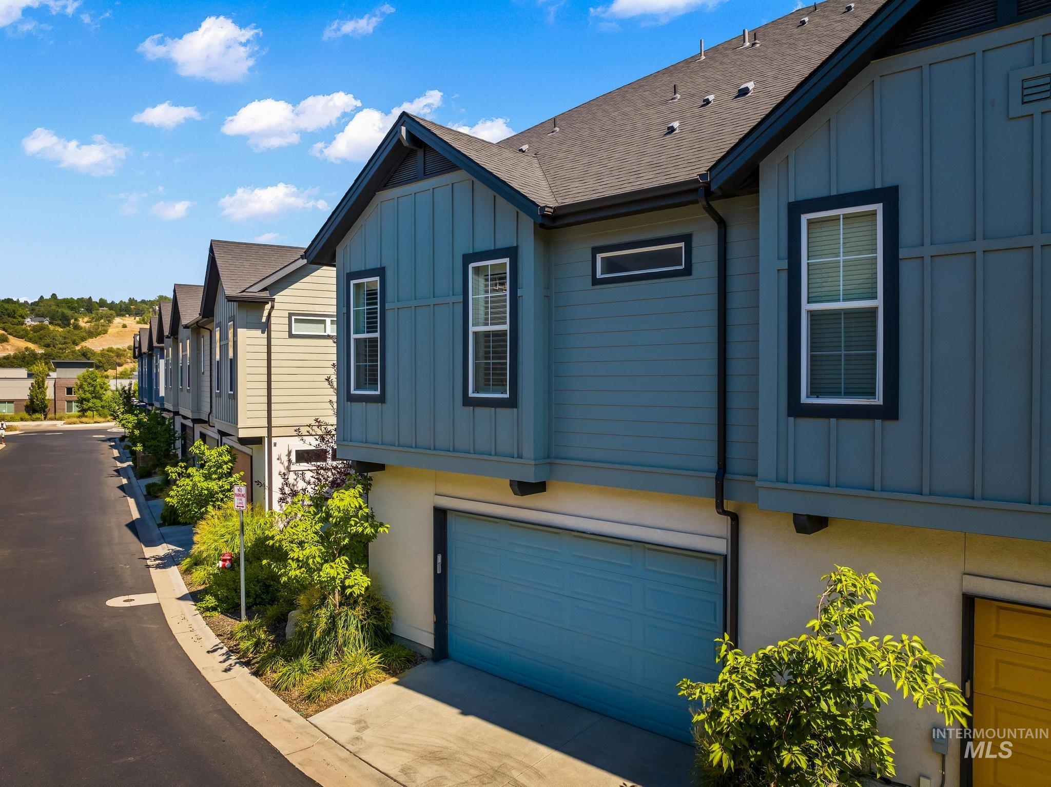 3362 East Exacta Lane Boise, ID 83716 - Photo 31 of 41 View of property exterior featuring board and batten siding, a garage, roof with shingles, and concrete driveway