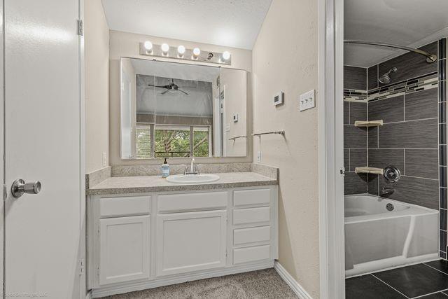 4557 North O'Connor Road, Unit 2281 Irving, TX 75062 - Photo 15 of 21 a bathroom with a granite countertop sink a mirror and a bathtub next to a window