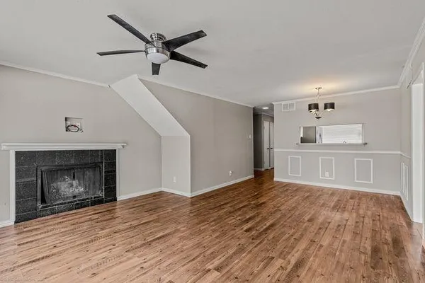 a view of empty room with wooden floor and fireplace