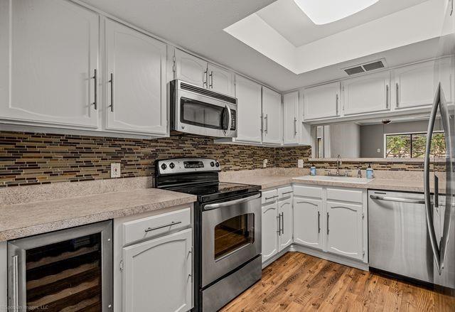 4557 North O'Connor Road, Unit 2281 Irving, TX 75062 - Photo 8 of 21 a kitchen with cabinets stainless steel appliances and wooden floor
