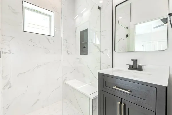 a bathroom with a sink vanity granite and a mirror