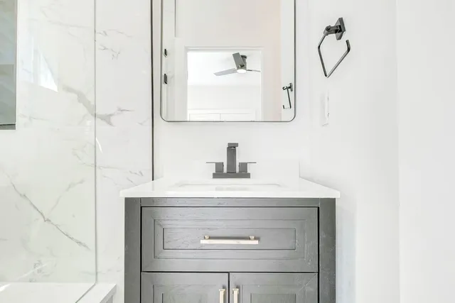 a bathroom with a sink vanity and a mirror