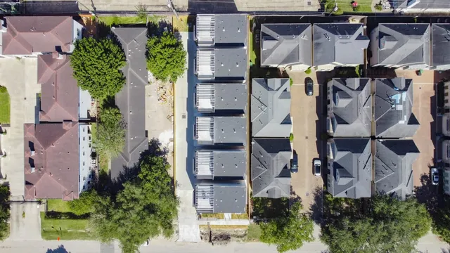 an aerial view of a house with a yard and large tree