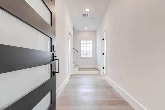 a view of a hallway with wooden floor and staircase