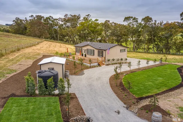 an aerial view of a house with garden space and lake view