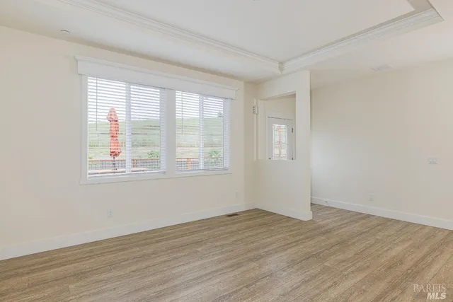 a view of a room that has wooden floor and windows in it