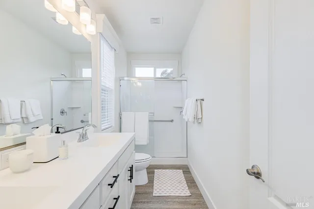 a bathroom with a sink a toilet and shower