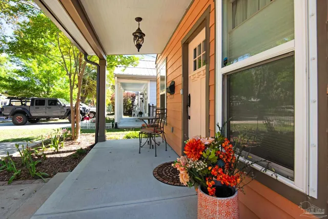 a view of a porch with chairs and potted plants