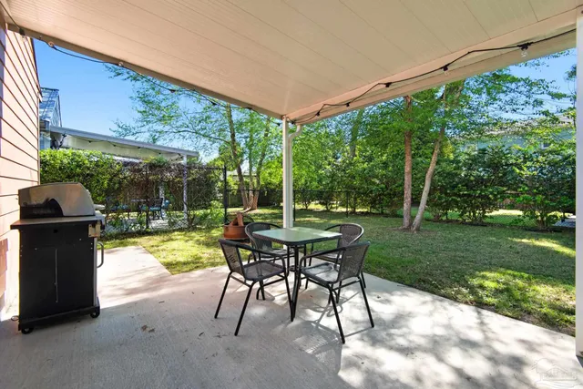 a view of a patio with a table chairs and a yard