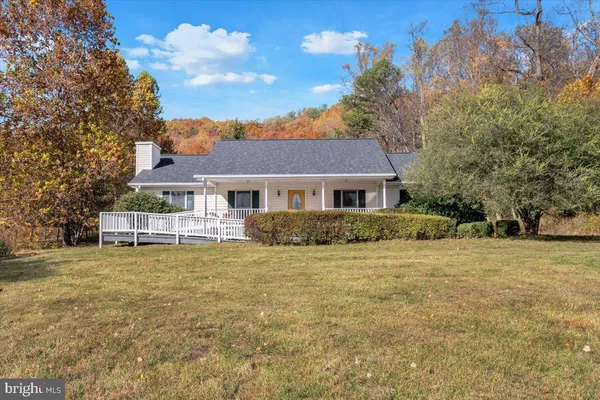a front view of a house with a garden and trees
