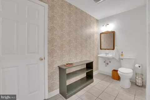 a bathroom with a toilet sink and mirror