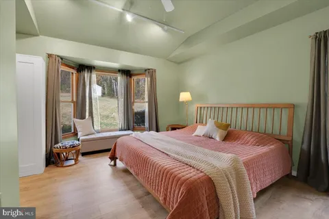 a bedroom with a bed and large windows