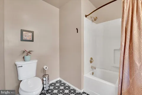 a white toilet sitting next to a bath tub