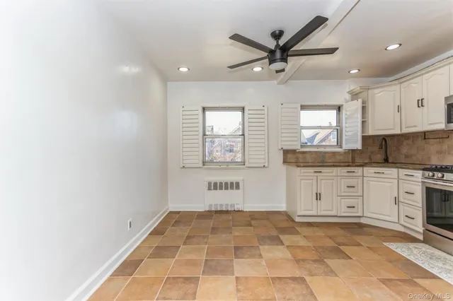 a kitchen with granite countertop a stove a sink and a refrigerator