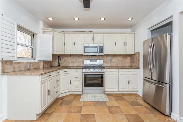 a kitchen with granite countertop stainless steel appliances a refrigerator sink and microwave