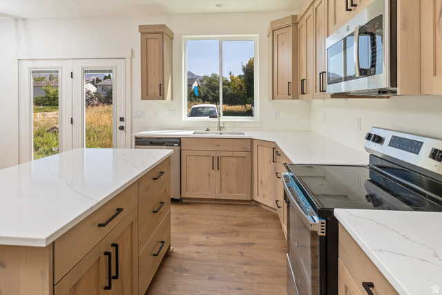 612 North 400 West Logan, UT 84321 - Photo 17 of 27 Kitchen featuring light wood-finish cabinetry with black hardware, white countertops, and wood-finish flooring
