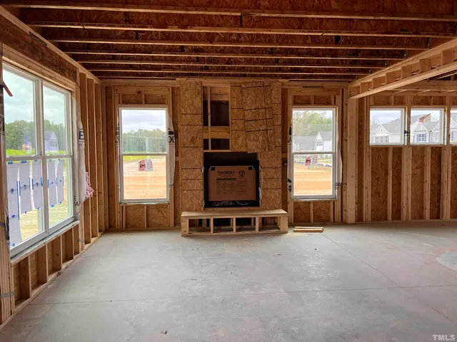 a view of an empty room with furniture and windows