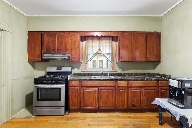 a kitchen with stainless steel appliances granite countertop a stove a sink and a microwave