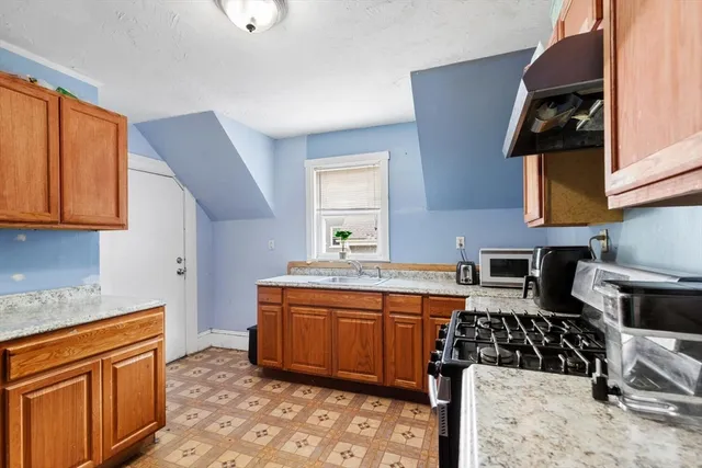 a kitchen with stainless steel appliances granite countertop a sink stove and cabinets