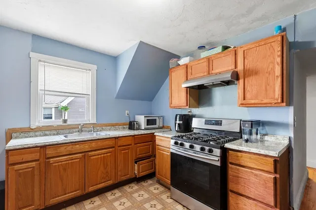 a kitchen with stainless steel appliances granite countertop a sink stove and cabinets