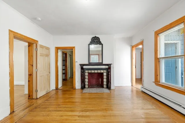 a view of an empty room with window and fire place