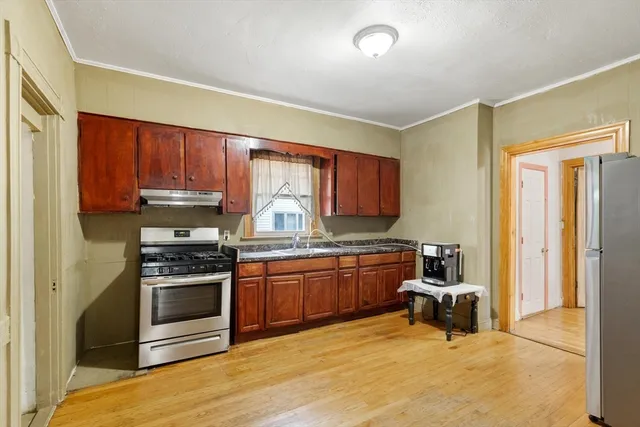 a kitchen with stainless steel appliances granite countertop a stove a sink and a refrigerator