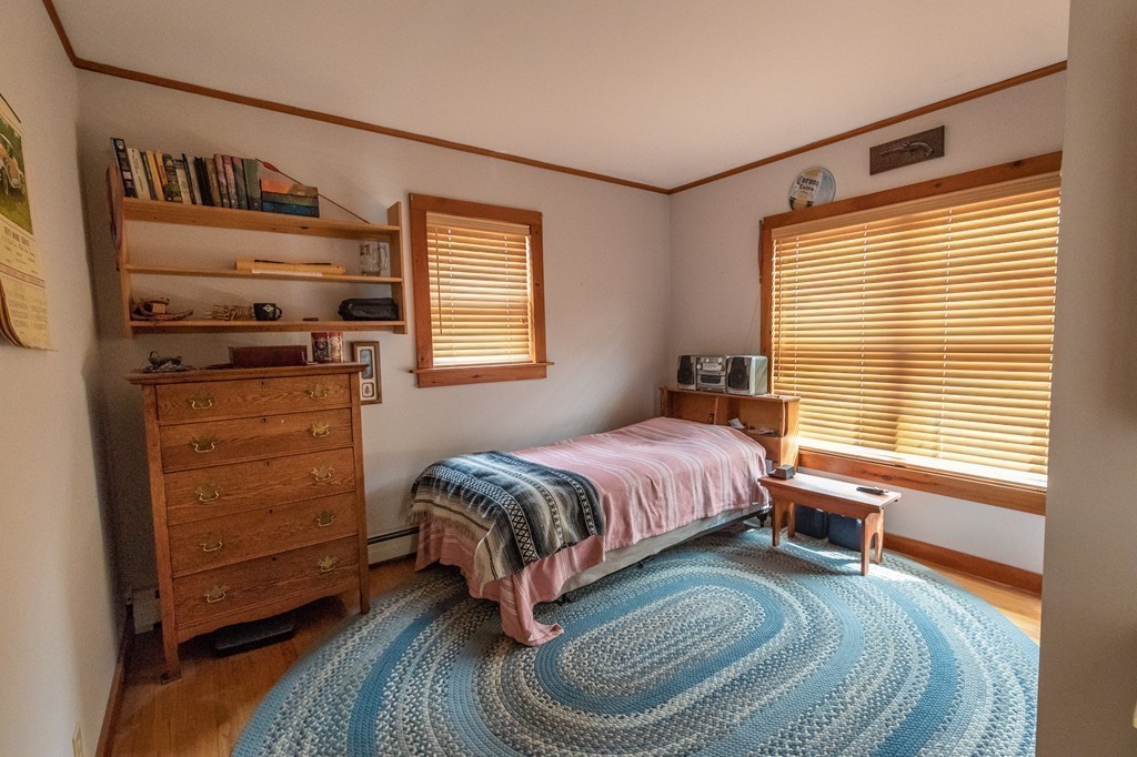 235 Bug Hill Road Ashfield, MA 01330 - Photo 9 of 30 a spacious bedroom with a bed a dresser next to a window