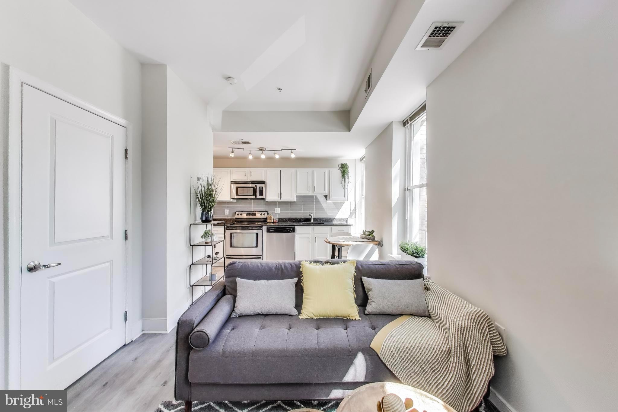 1106 Columbia Road Northwest, Unit 103 Washington, DC 20009 - Photo 4 of 21 a living room with furniture and a window