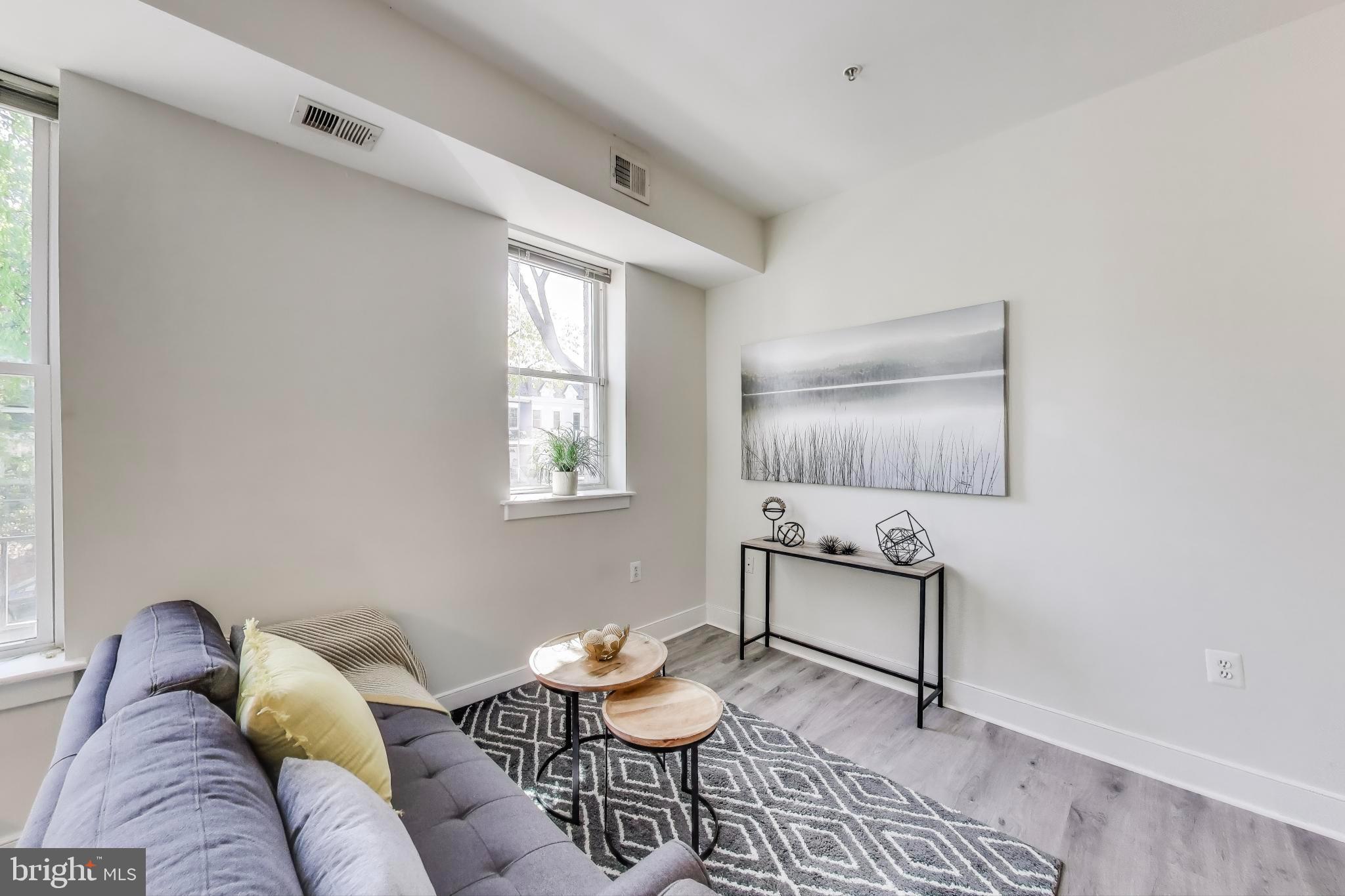 1106 Columbia Road Northwest, Unit 103 Washington, DC 20009 - Photo 5 of 21 a living room with furniture and window