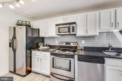 a kitchen with stainless steel appliances granite countertop a refrigerator stove and sink