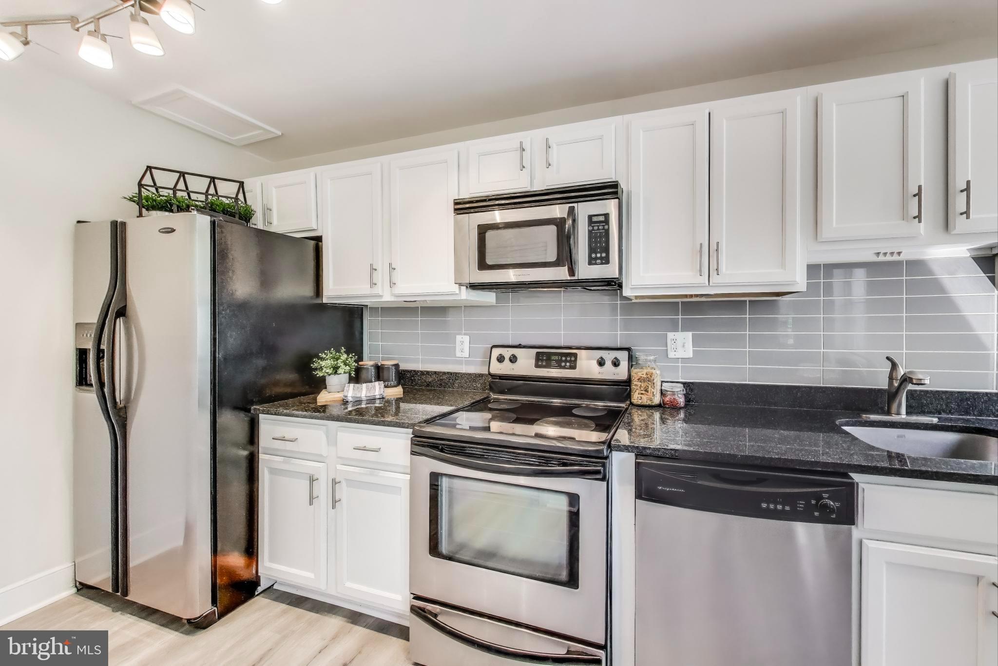1106 Columbia Road Northwest, Unit 103 Washington, DC 20009 - Photo 7 of 21 a kitchen with stainless steel appliances granite countertop a refrigerator stove and sink