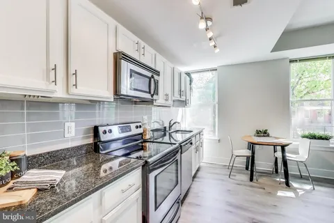 a kitchen with stainless steel appliances granite countertop a sink stove and cabinets
