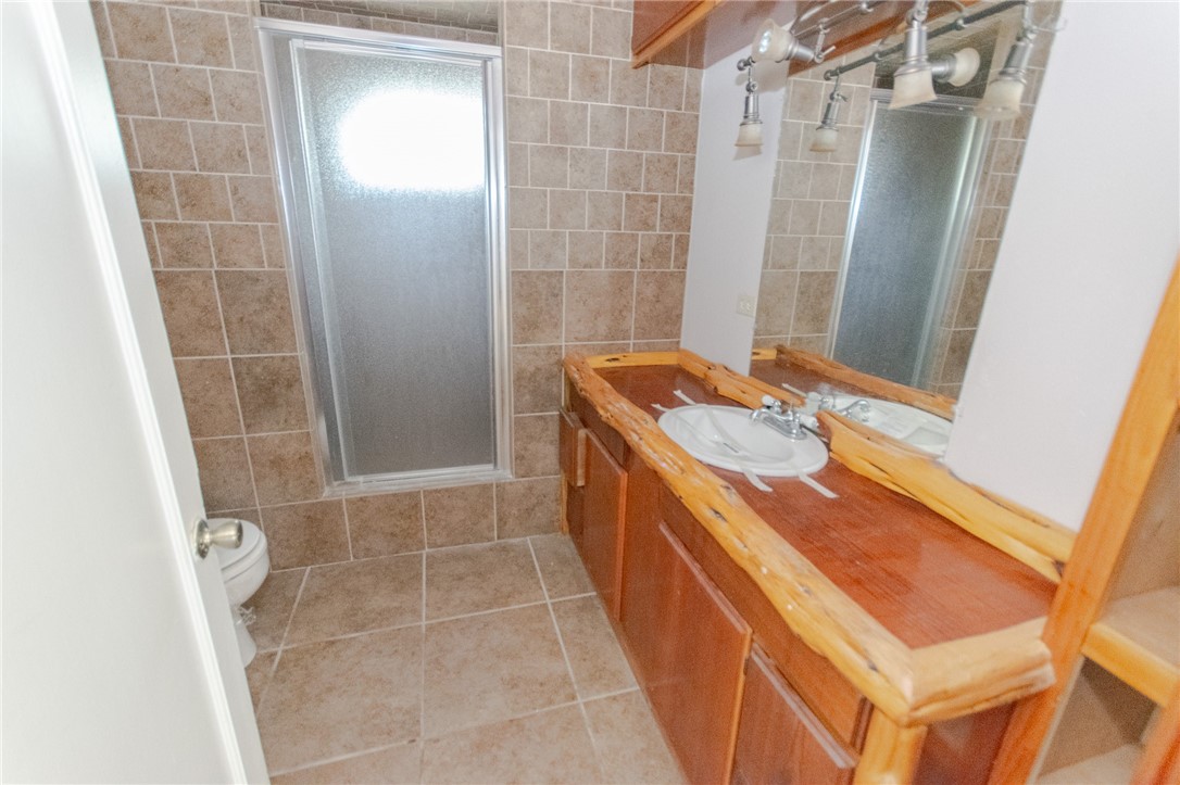 3867 Highway 59 George West, TX 78022 - Photo 15 of 40 a bathroom with a sink a toilet a shower and a mirror