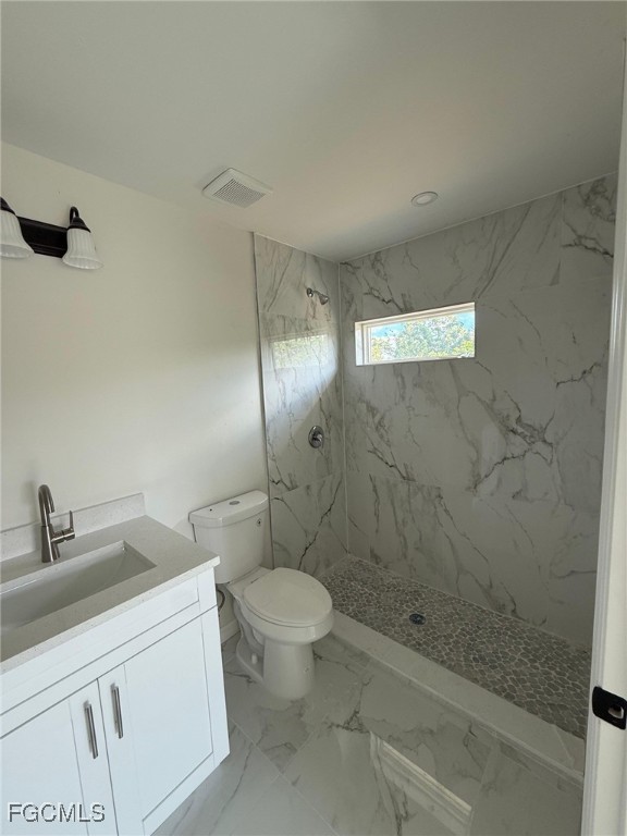 4657-4659 26th Street Southwest Lehigh Acres, FL 33973 - Photo 20 of 24 a bathroom with a granite countertop sink a toilet and shower