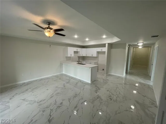 a view of a kitchen with a sink and a refrigerator
